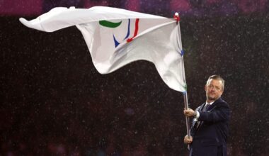 Breaking news event with journalists gathered, microphones ready, and a prominent speaker addressing the press conference