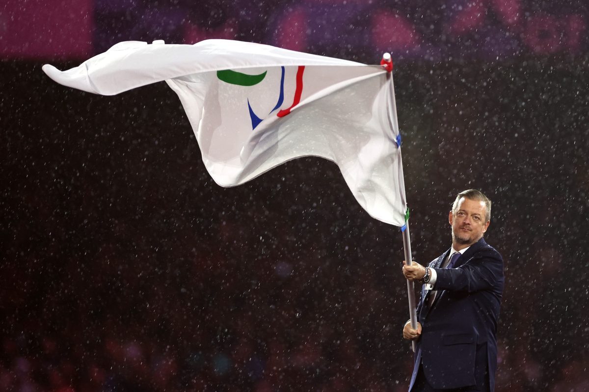 Breaking news event with journalists gathered, microphones ready, and a prominent speaker addressing the press conference