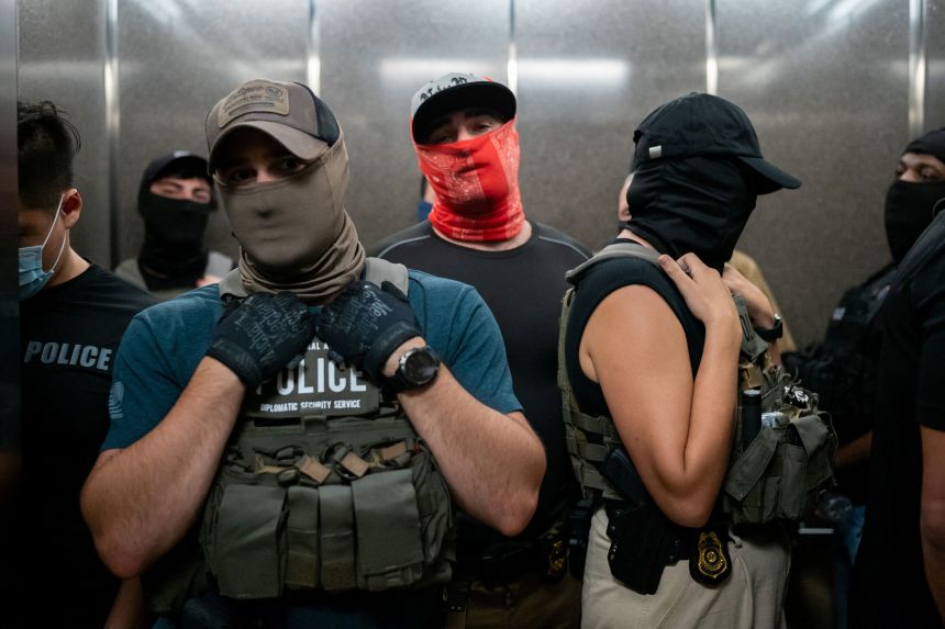 Masked federal immigration officers take the elevator at immigration court in Manhattan on July 17.