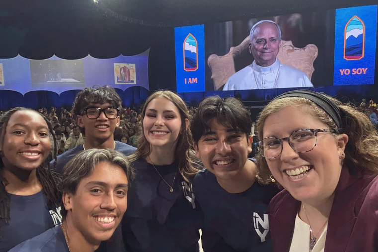 Teens Mia Smothers, Ezequiel Ponce, Micah Alcisto, Elise Wing, and Chris Pantelakis, and moderator Katie McGrady, right, take a “selfie” with Pope Leo XIV during a live digital encounter at Lucas Oil Stadium on Nov. 21, 2025.