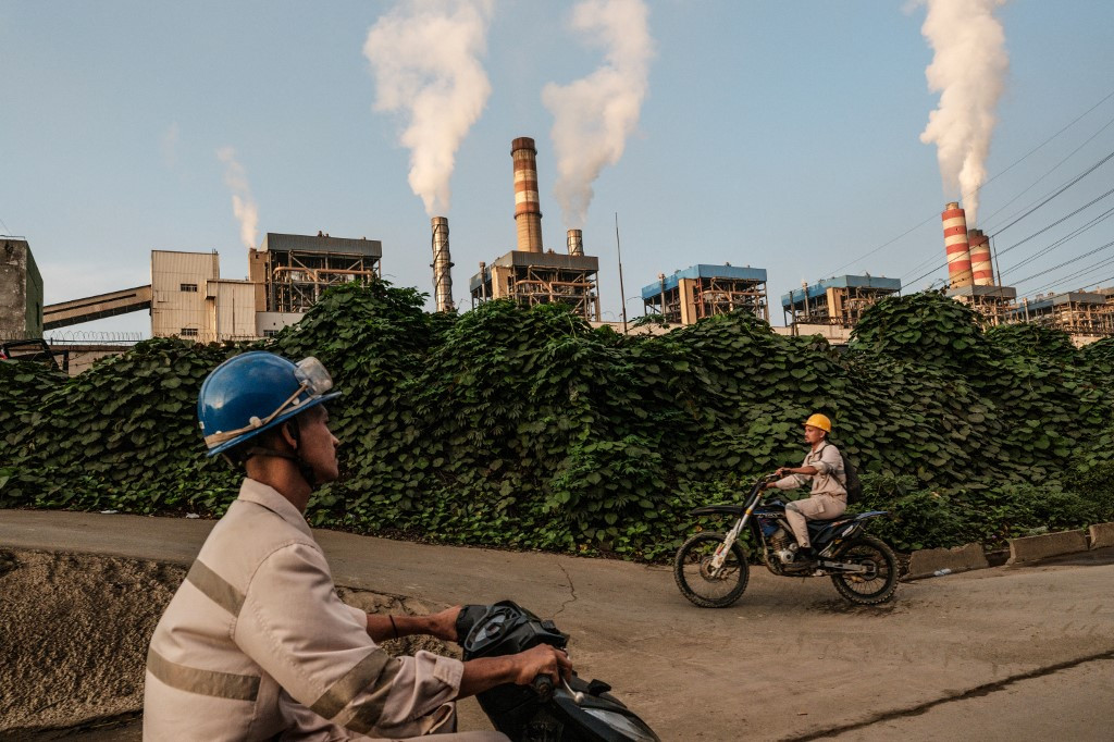 Workers ride motorbikes in the morning of April 18, toward Weda Bay Industrial Park (WBIP), a major nickel-processing and smelting hub, in Lelilef Sawai, Central Halmahera, North Maluku.