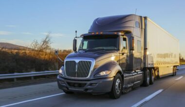 A big rig tractor trailer semi truck on a freeway.