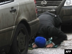 A Muslim man prays between cars outside a mosque in Moscow. (file photo)