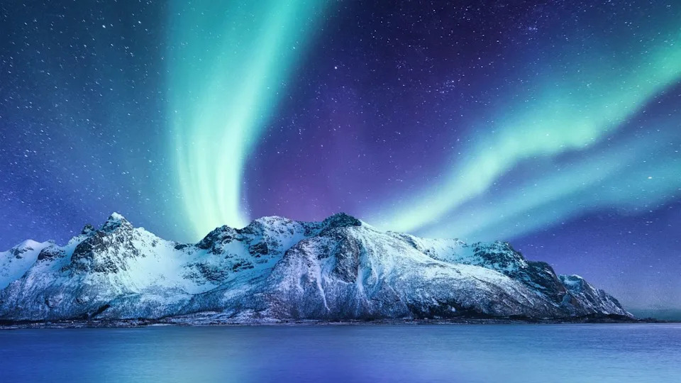 Aurora Borealis, Lofoten islands, Norway. Northen lights, mountains and reflection on the water. Winter landscape during polar lights. Norway travel - image