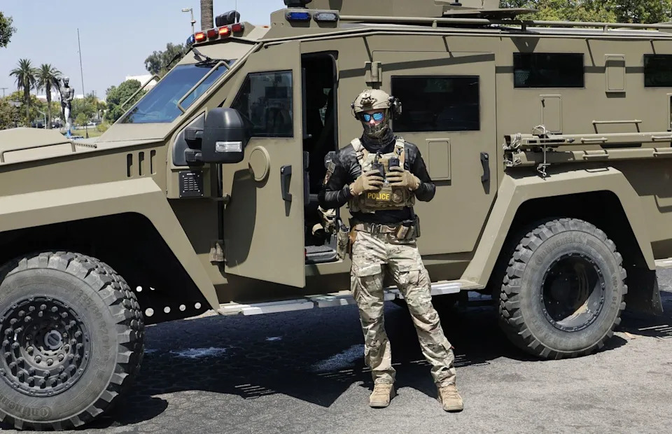 Carlin Steihl / Los Angeles Times via Getty A federal immigration agent standing outside their vehicle