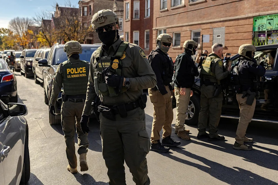 Jim Vondruska/Reuters - PHOTO: Federal agents stand off with community members during immigration raids