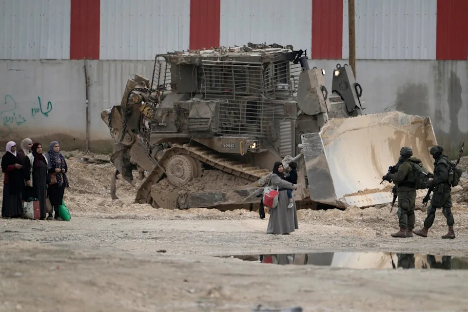 Israeli soldiers check the identification cards of Palestinians while they evacuate their homes in the West Bank refugee camp of Nur Shams, near Tulkarem, while the Israeli military operation continues in the area on 11 February (Copyright 2025 The Associated Press. All rights reserved)