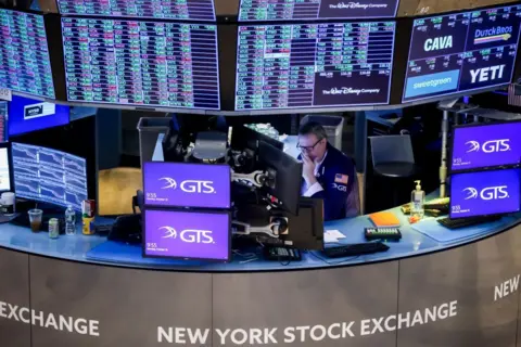 Getty Images A sole trader surrounded by screens on the floor of the New York Stock Exchange