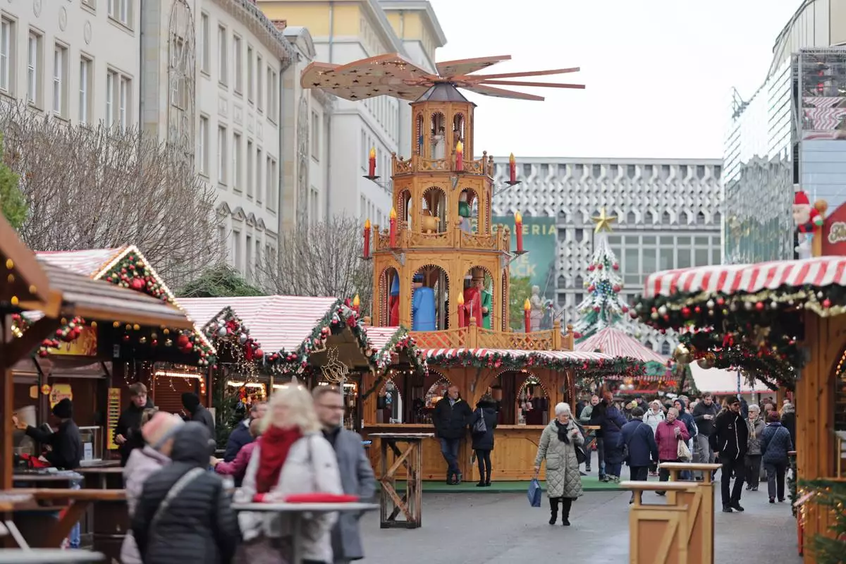 Visitors walk through the Magdeburg Christmas market, in Magdeburg, Germany, Thursday, Nov. 20, 2025. (Matthias Bein/dpa via AP)