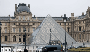 Police stand near the pyramid of the Louvre museum after reports of a robbery, in Paris, France, October 19, 2025