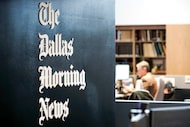 The Dallas Morning News masthead is displayed on a wall in the newsroom on Monday, Sept. 22,...