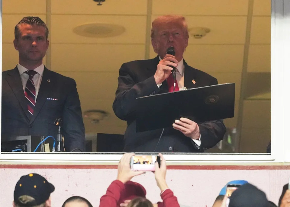 President Donald Trump delivers the Oath of Enlistment alongside Defense Secretary Pete Hegseth, left, during an NFL football game between the Washington Commanders and the Detroit Lions at Northwest Stadium in Landover, Md., Sunday (AP)