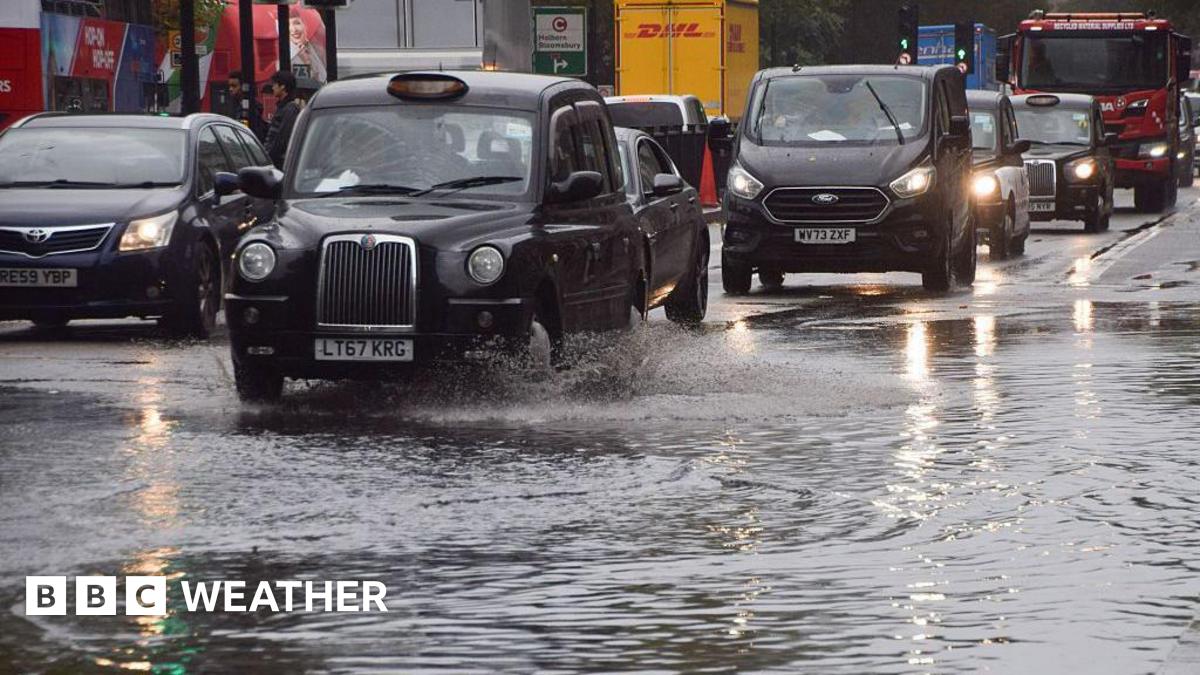 flooded street with cars and taxi's driving through it