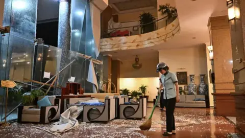 AFP via Getty Images Image shows a person sweeping up debris in a hotel in Vietnam.