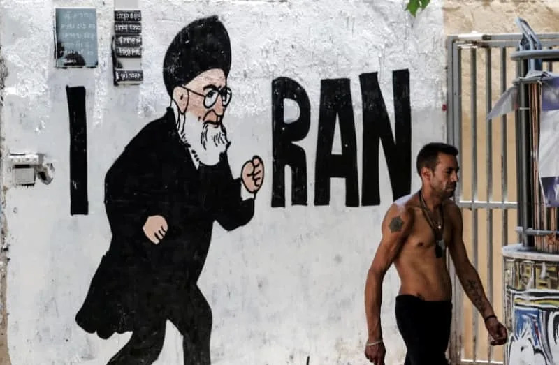An Israeli man walks past a new graffiti of Iran's Supreme Leader Ayatollah Ali Khamenei following the 12 days war between Israel and Iran, in Tel Aviv, Israel July 8, 2025 (credit: REUTERS/NIR ELIAS)