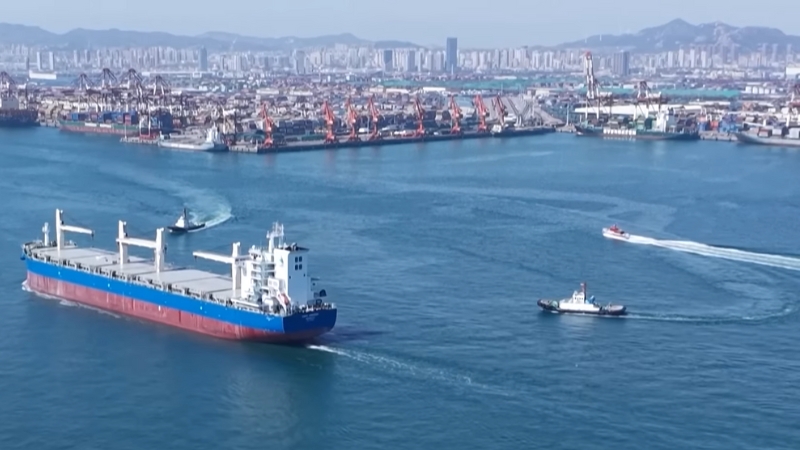A cargo ship navigating through a port, symbolizing global trade routes impacted by U.S.-China trade tensions
