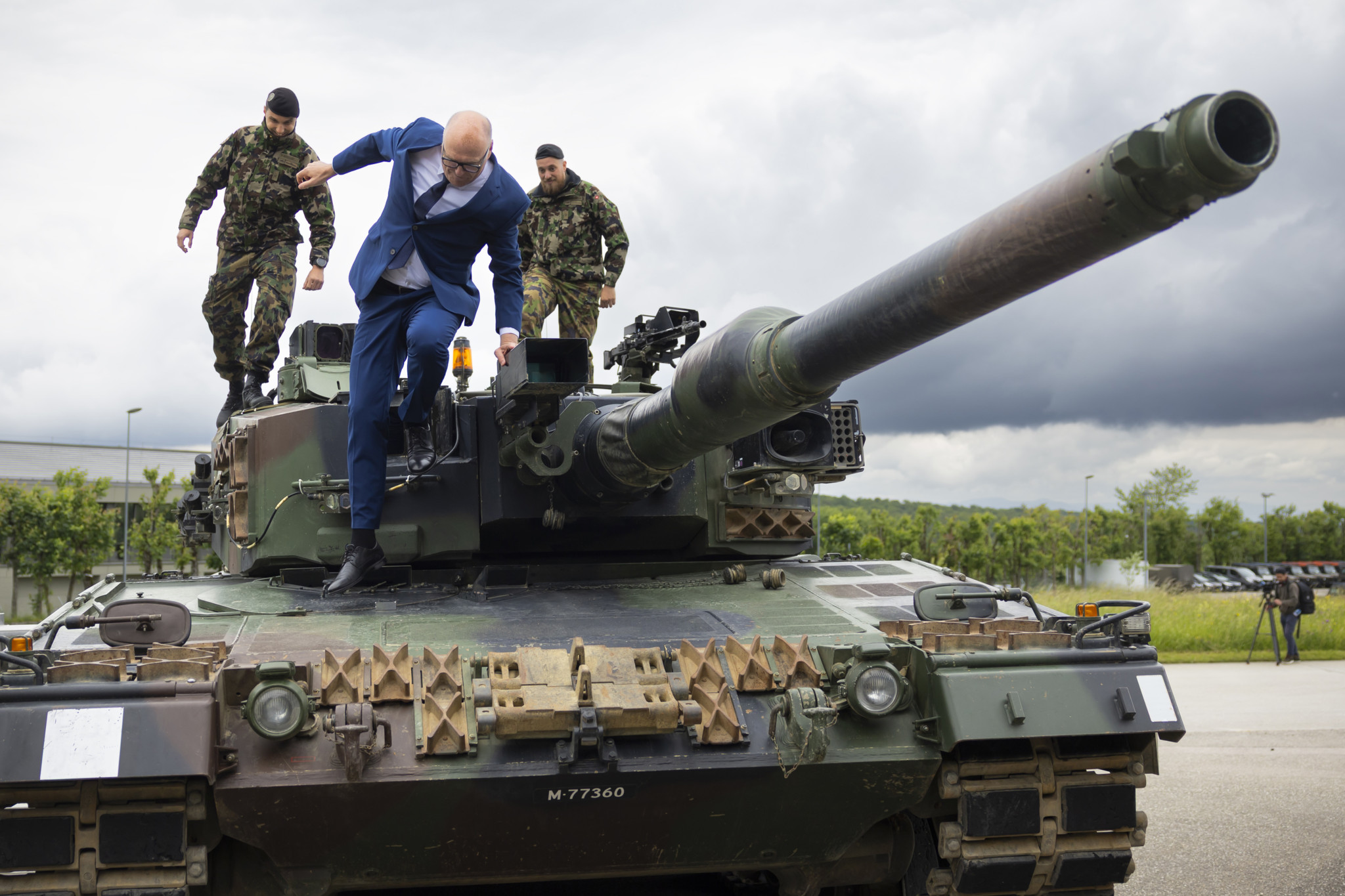 Bundesrat Martin Pfister steigt von einem Leopard 2 Panzer auf dem Waffenplatz in Bure nach einer Sicherheitskonferenz am 26. Mai 2025 herab, begleitet von Soldaten.