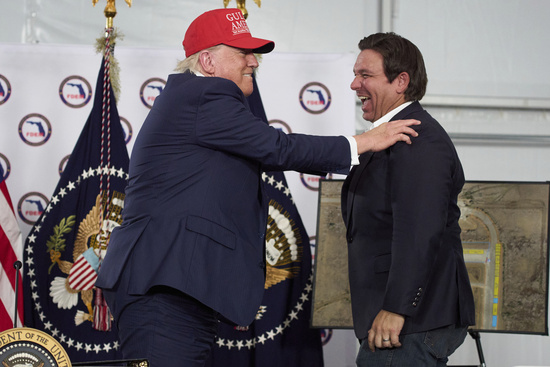 President Donald Trump talks with Gov. Ron DeSantis, R-Fla., during a roundtable at "Alligator Alcatraz," a new migrant detention facility at Dade-Collier Training and Transition facility, Tuesday, July 1, 2025, in Ochopee, Fla. (AP Photo/Evan Vucci)