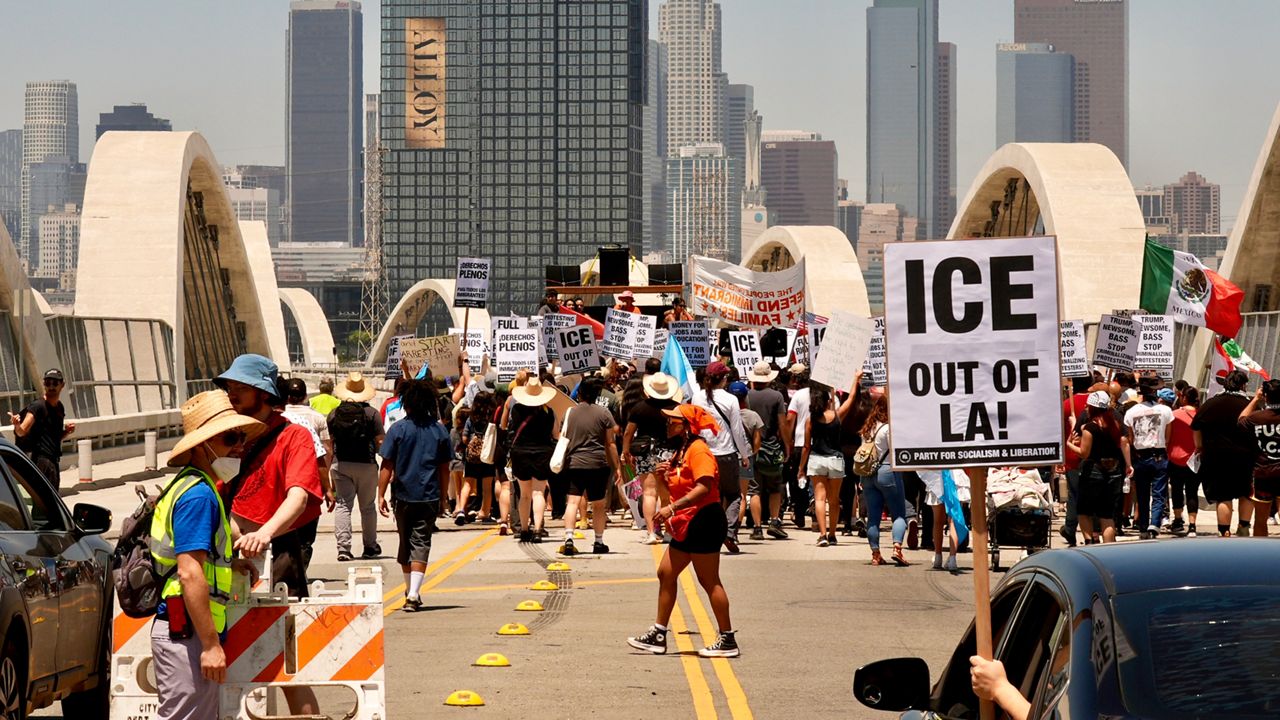 Demonstrators close temporarily the Sixth Street bridge after a rally at Hollenbeck Park calling for an end to the immigration raids by ICE in Los Angeles, July 1, 2025. (AP Photo/Damian Dovarganes)
