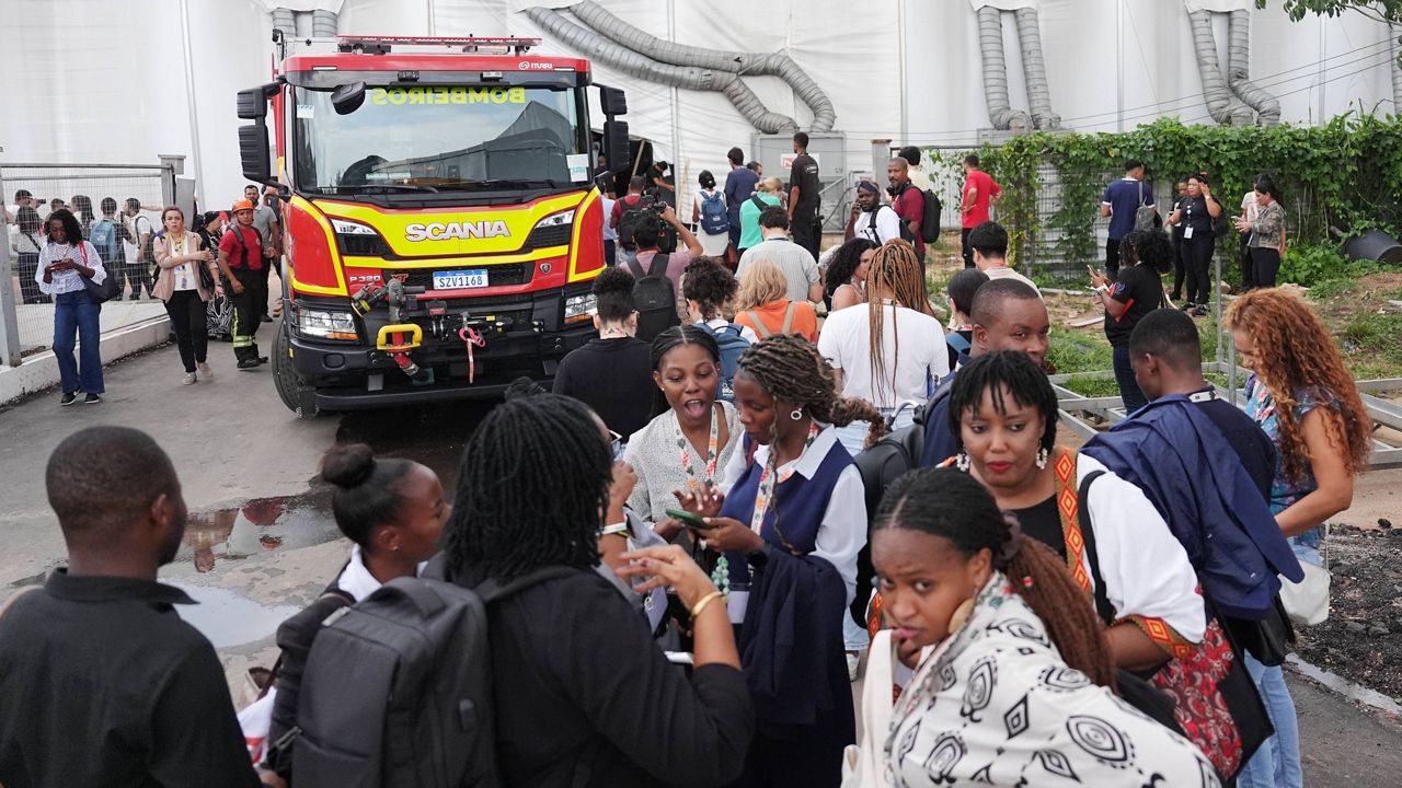 Attendees evacuate after a fire was reported inside the venue for the COP30 U.N. Climate Summit, Thursday, Nov. 20, 2025, in Belem, Brazil. (AP Photo/Joshua A. Bickel)