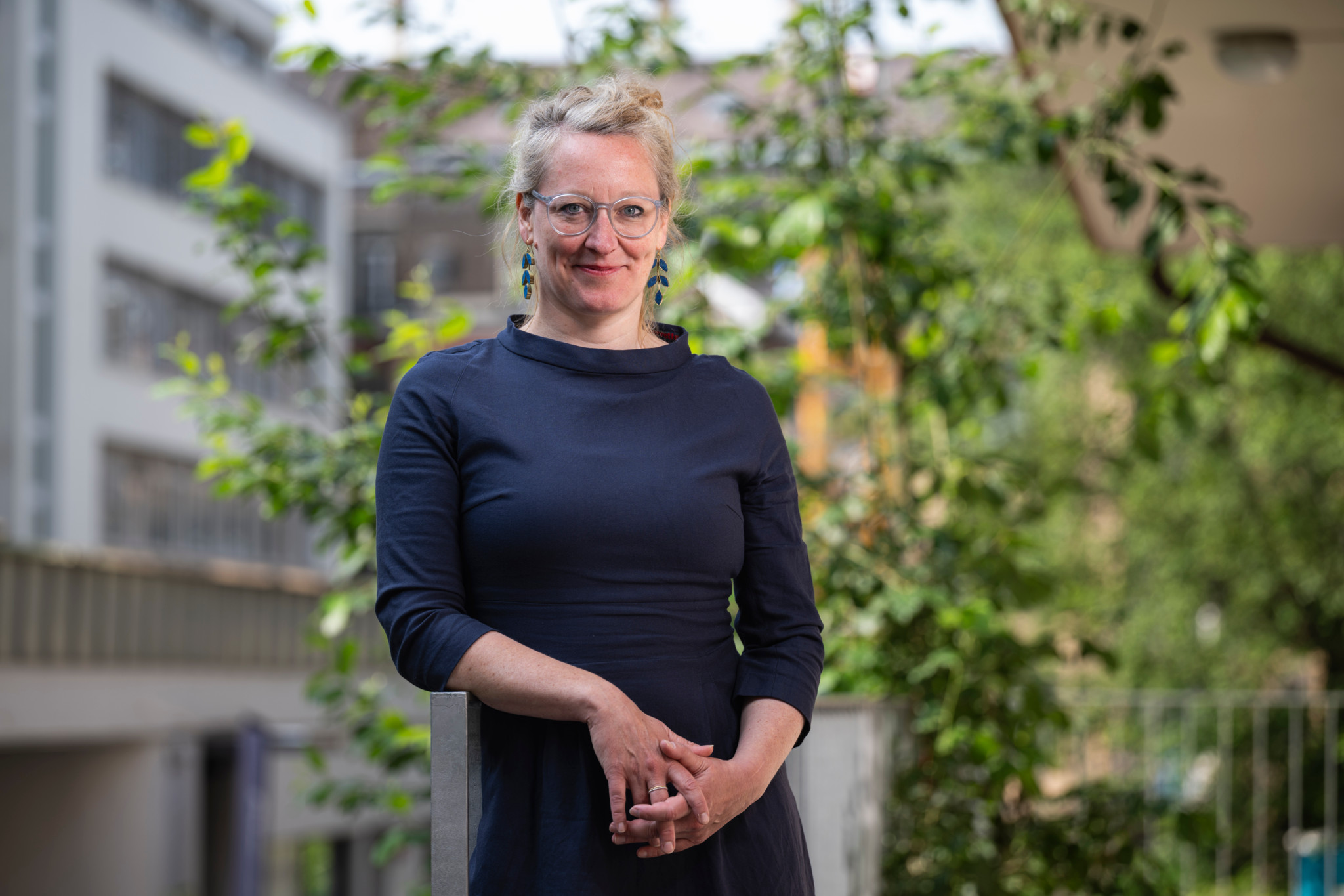 Aline Trede, Nationalrätin der Grünen, steht vor einem Gebäude in Bern, umgeben von Grünpflanzen. Aline Trede, Nationalrätin der Grünen, steht vor einem Gebäude in Bern, umgeben von Grünpflanzen.