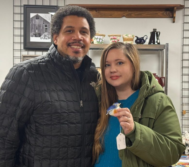 a man and woman holding up a Christmas ornament