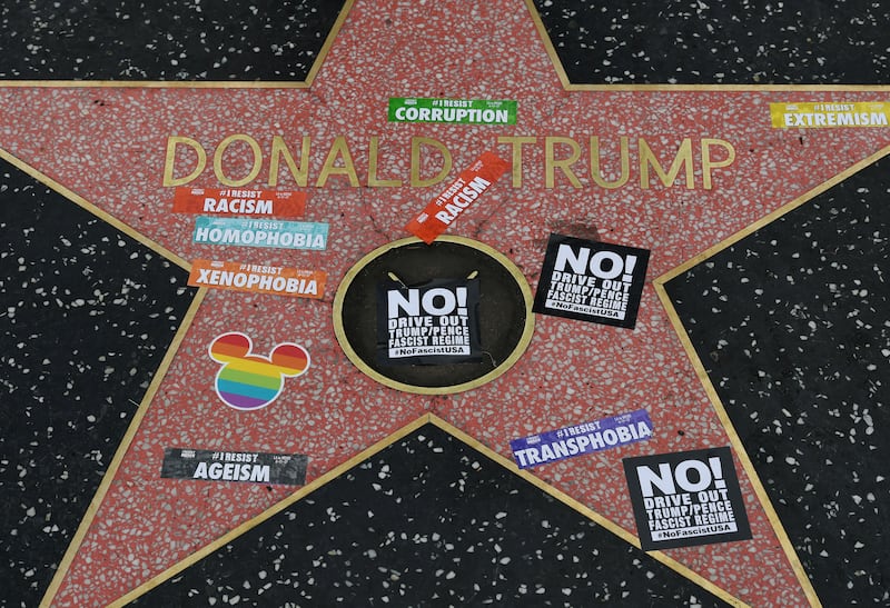 Gay pride stickers placed on the Hollywood Walk of Fame Star of President Donald Trump before the start of #ResistMarch during the 47th annual LA Pride Festival in Hollywood, California on June 11, 2017.