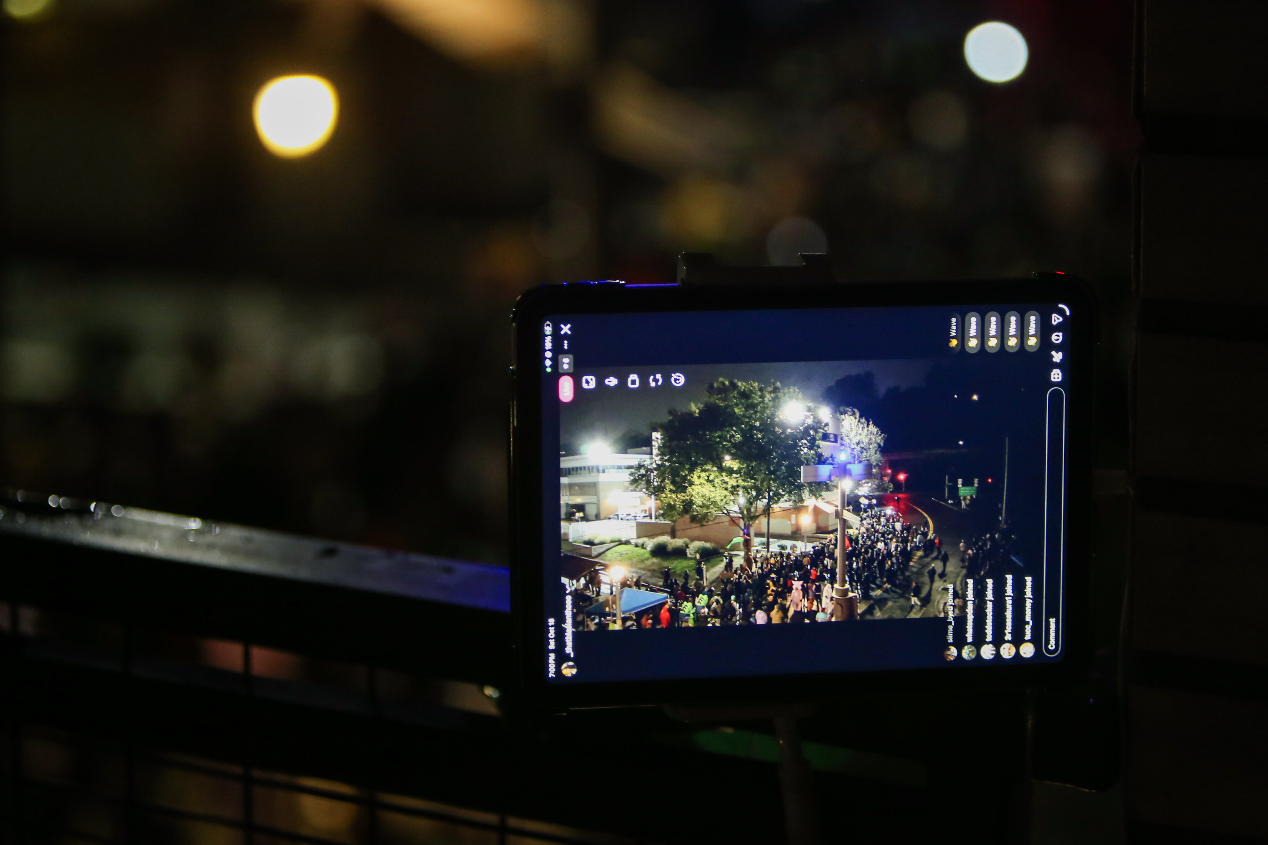 Gray’s Landing resident Mindan Ocon streams a protest outside the U.S. Immigration and Customs Enforcement building across the street from her apartment in South Portland on Saturday, Oct. 18, 2025.