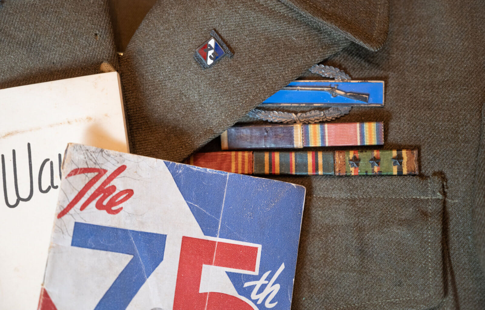World War II veteran Vernon Brantley's military ribbons and Combat Infantryman Badge on his old uniform.