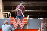 Workers install the W at the Whataburger restaurant at Globe Life Field in Arlington on...