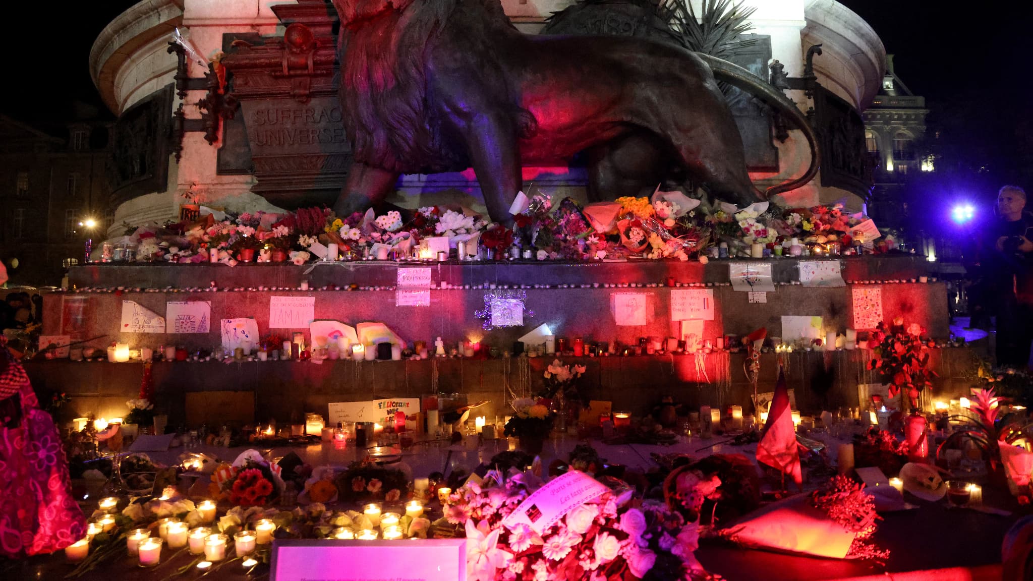 Des bougies brûlent parmi les fleurs et les messages devant un mémorial temporaire place de la République en hommage aux victimes des attentats terroristes de 2015 à Paris, le 12 novembre 2025.