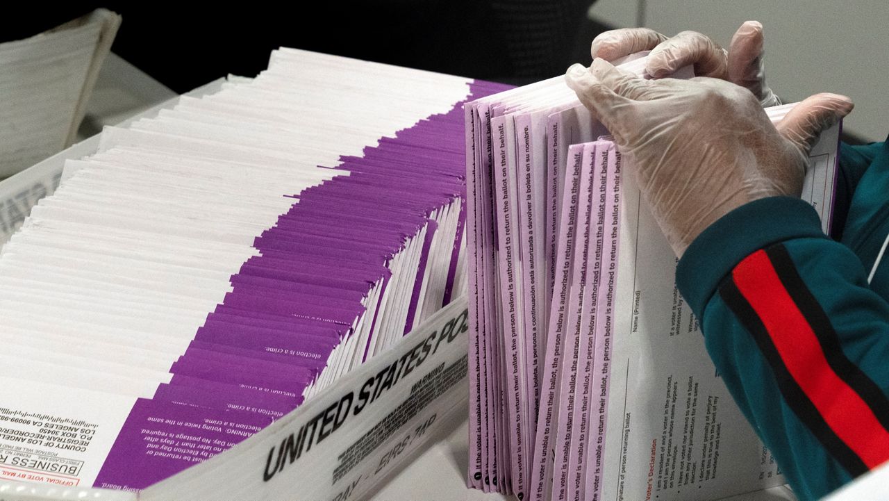 An election worker checks on signed signatures on mail-in ballots at the new Los Angeles County Ballot Processing Center in the City of Industry, Calif. on Thursday, Feb. 29, 2024. (AP Photo/Richard Vogel, File)
