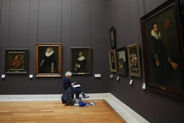 A woman draws in the Richelieu gallery of Le Louvre museum are seen Wednesday, Nov. 19, 2025 in Paris. (AP Photo/Christophe Ena)