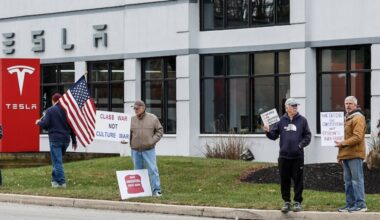People protest Saturday at the Devon Tesla dealership in response to the company's shareholders awarding Elon Musk more than a trillion dollars.