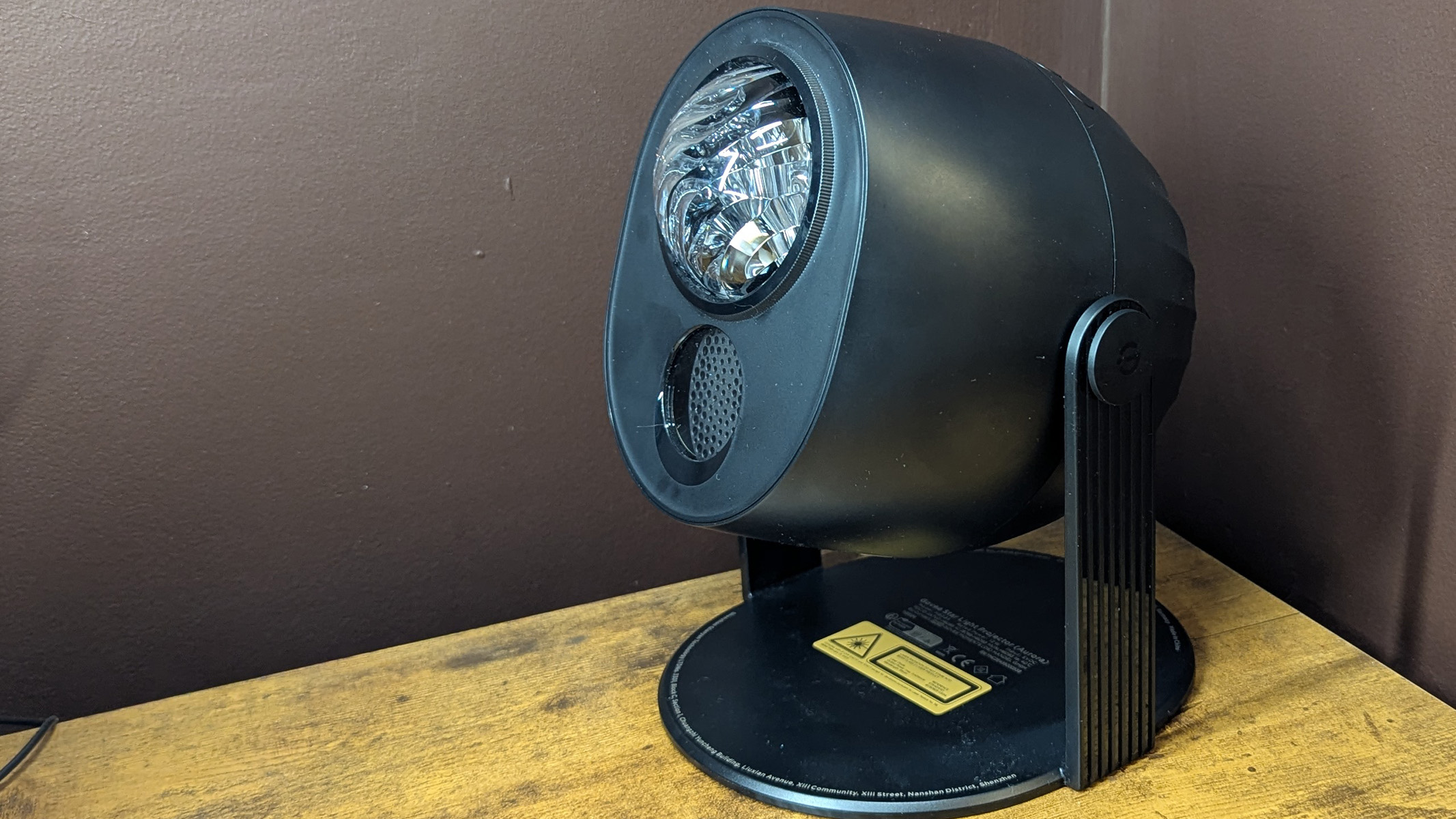 Govee projector on a wooden desk with a brown wall in the background