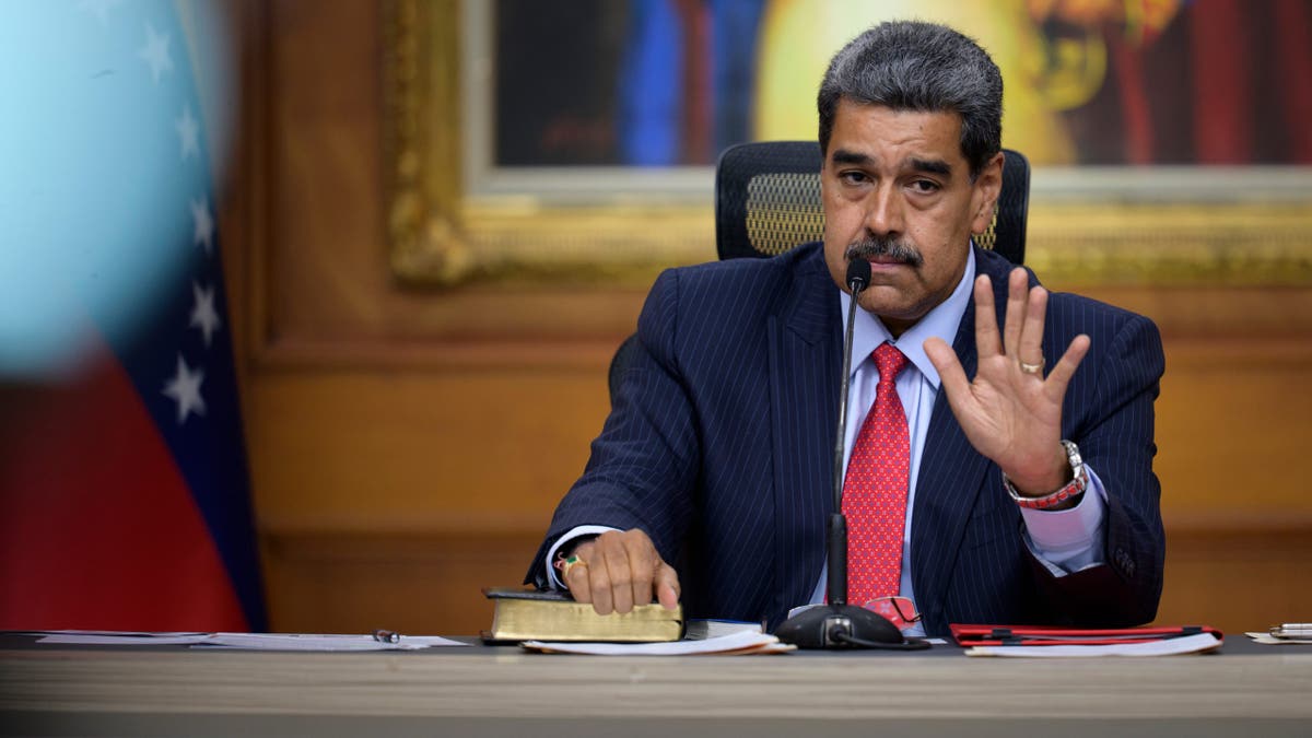 Nicolás Maduro with his hand raised.