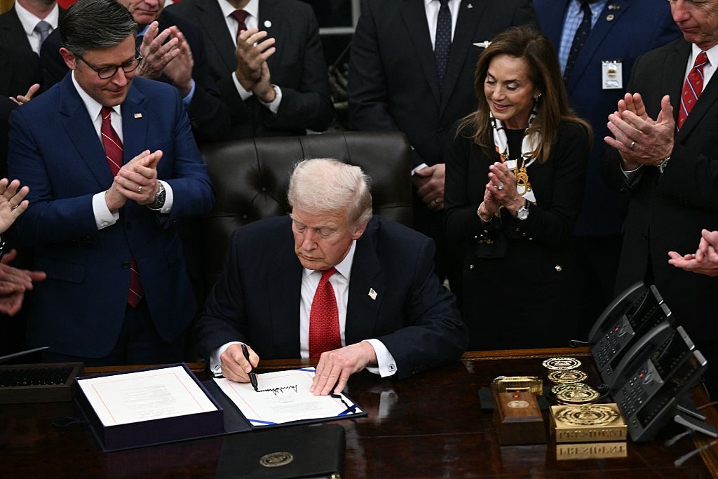 President Donald Trump signs a spending package to reopen the federal government in the Oval Office at the White House on Wednesday night. (Brendan Smialowski/AFP via Getty Images)