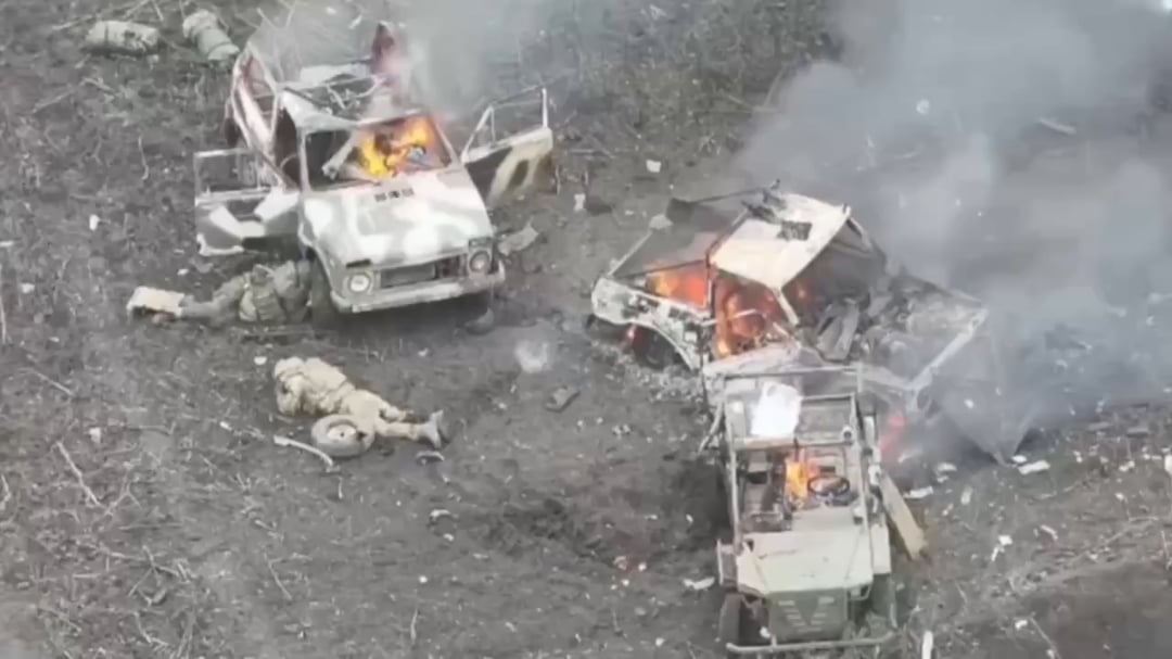 A liquidated russian assault group lying next to three burning assault vehicles. November 2025.