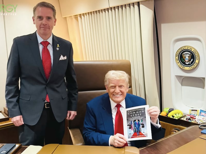 Scott Jennings next to Donald Trump promoting his book.
