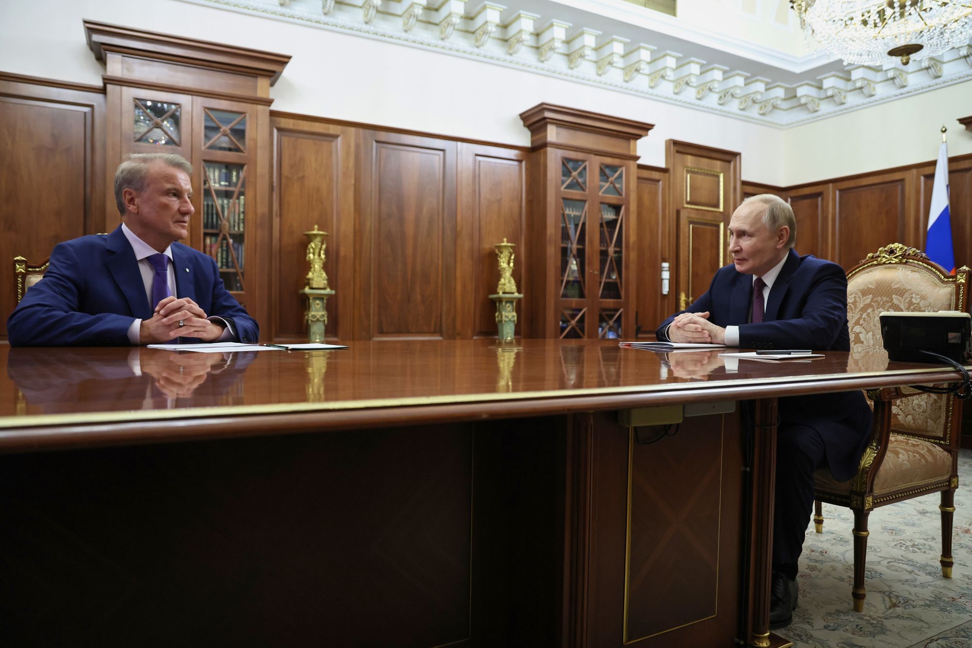 Russian president Vladimir Putin speaks to Sberbank CEO German Gref during their meeting at the Kremlin in Moscow