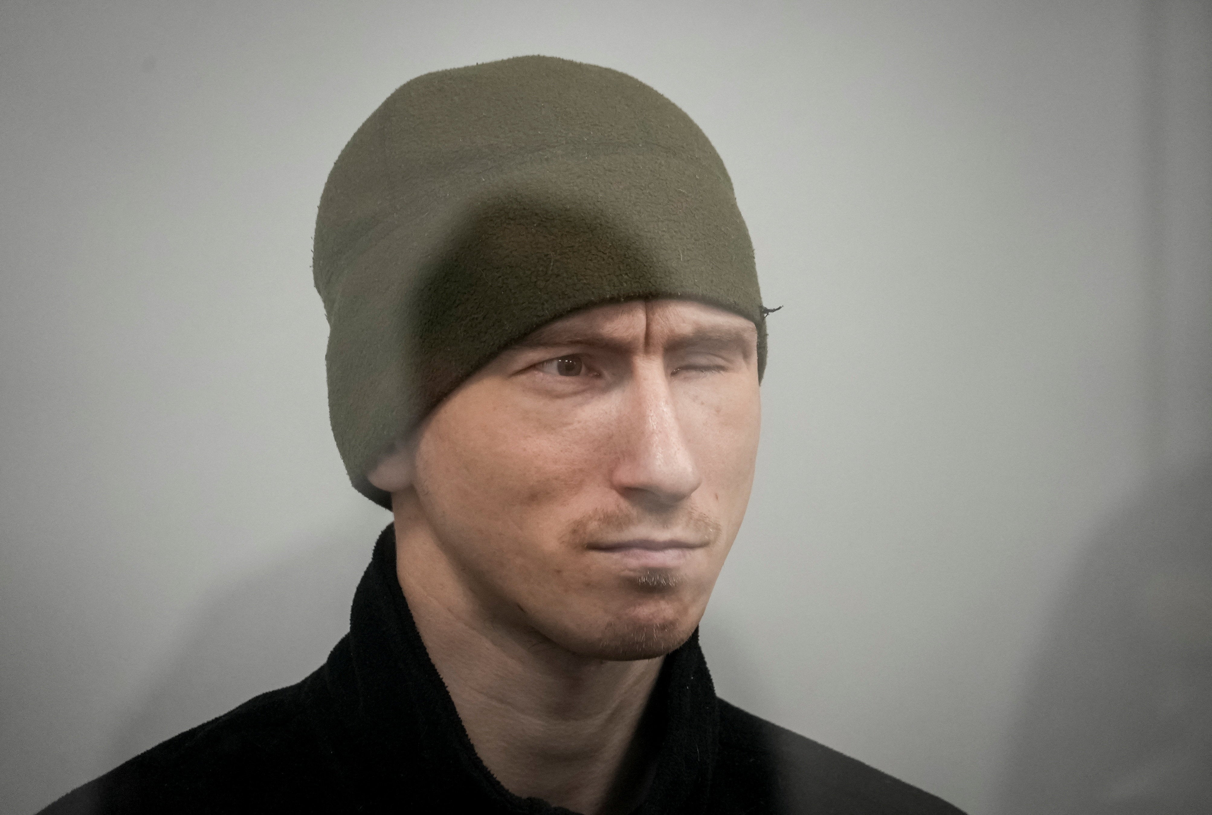 Russian soldier Dmitry Kurashov accused of committing a war crime by executing a Ukrainian serviceman who had surrendered during combat, sits inside a cage during a court hearing expected to deliver a verdict in Zaporizhzhia