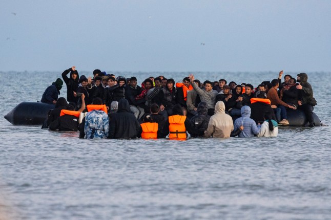 Migrants try to board a crowded smuggler's boat in an attempt to cross the English Channel off the beach of Gravelines, northern France on September 19, 2025. As an agreement for the return to France of undocumented migrants and asylum seekers arriving in Britain in small boats is being haltingly implemented, an undiminished number of people are attempting the cross-Channel journey and taking advantage of stable weather. (Photo by Sameer Al-DOUMY / AFP) (Photo by SAMEER AL-DOUMY/AFP via Getty Images)