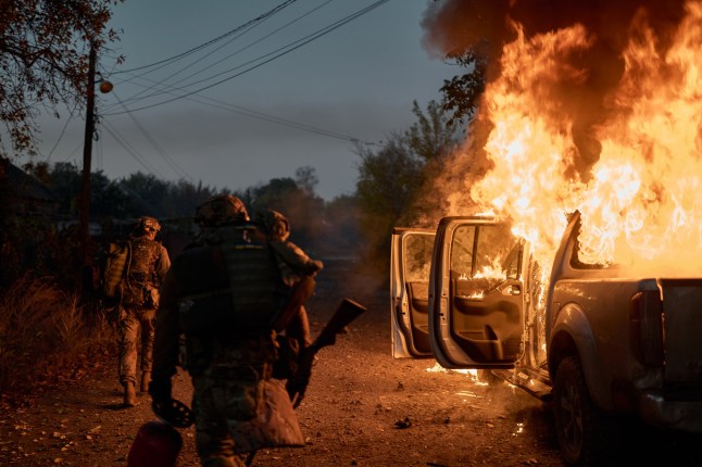 KOSTIANTYNIVKA, UKRAINE - OCTOBER 16: Ukrainian soldiers inspect a vehicle recently struck by a Russian FPV kamikaze drone that ambushed them near the frontline on October 16, 2025 in Kostiantynivka, Ukraine. The frontline city of Kostiantynivka lies in ruins after months of relentless Russian assaults, with destroyed buildings, empty streets, and traces of both military presence and civilian survival visible throughout the area. (Photo by Kostiantyn Liberov/Libkos/Getty Images)