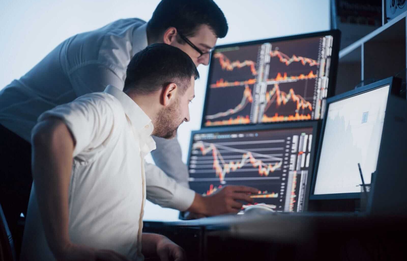Stock brokers analyzing stocks on screen by Standret via Shutterstock