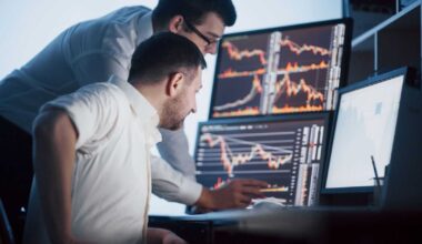 Stock brokers analyzing stocks on screen by Standret via Shutterstock