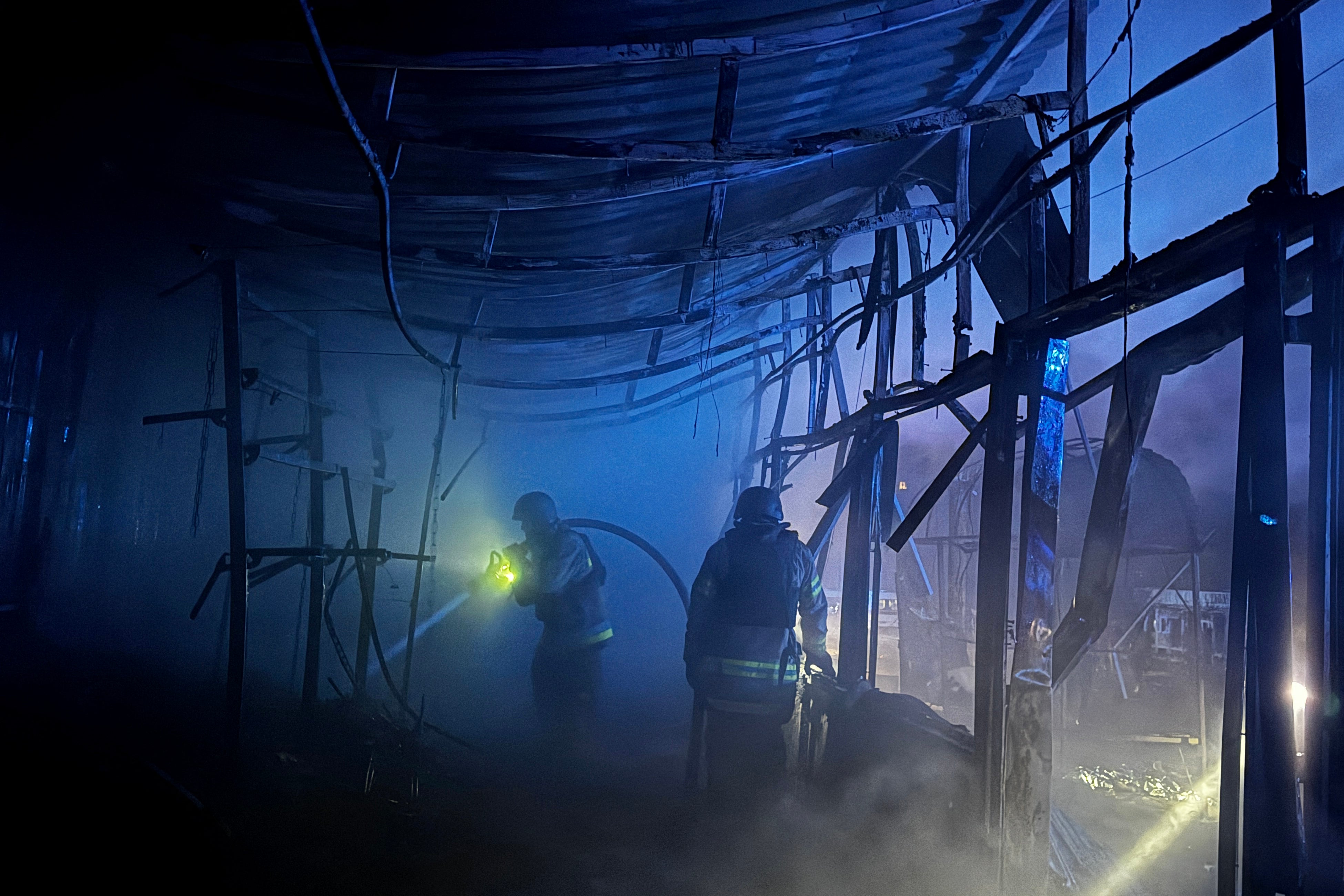 Ukrainian rescuers work at the site of an air attack in Zaporizhzhia, on 20 November