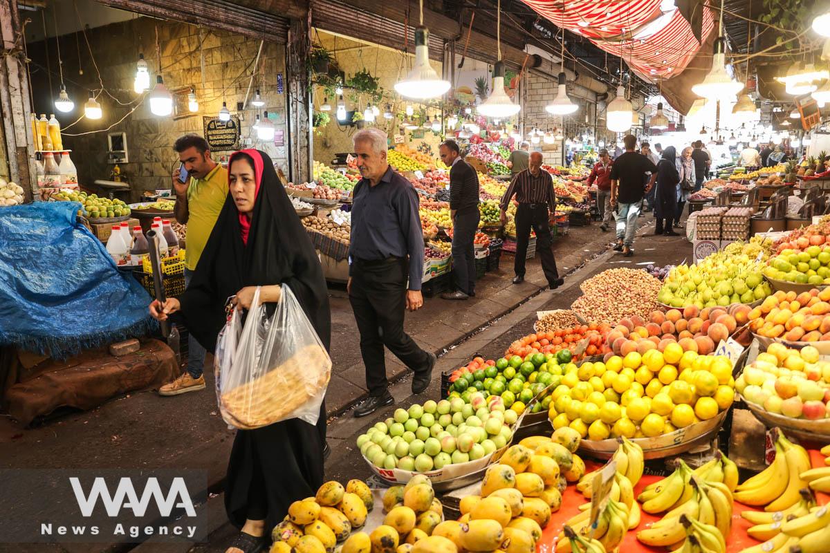 People walk past shops in a street