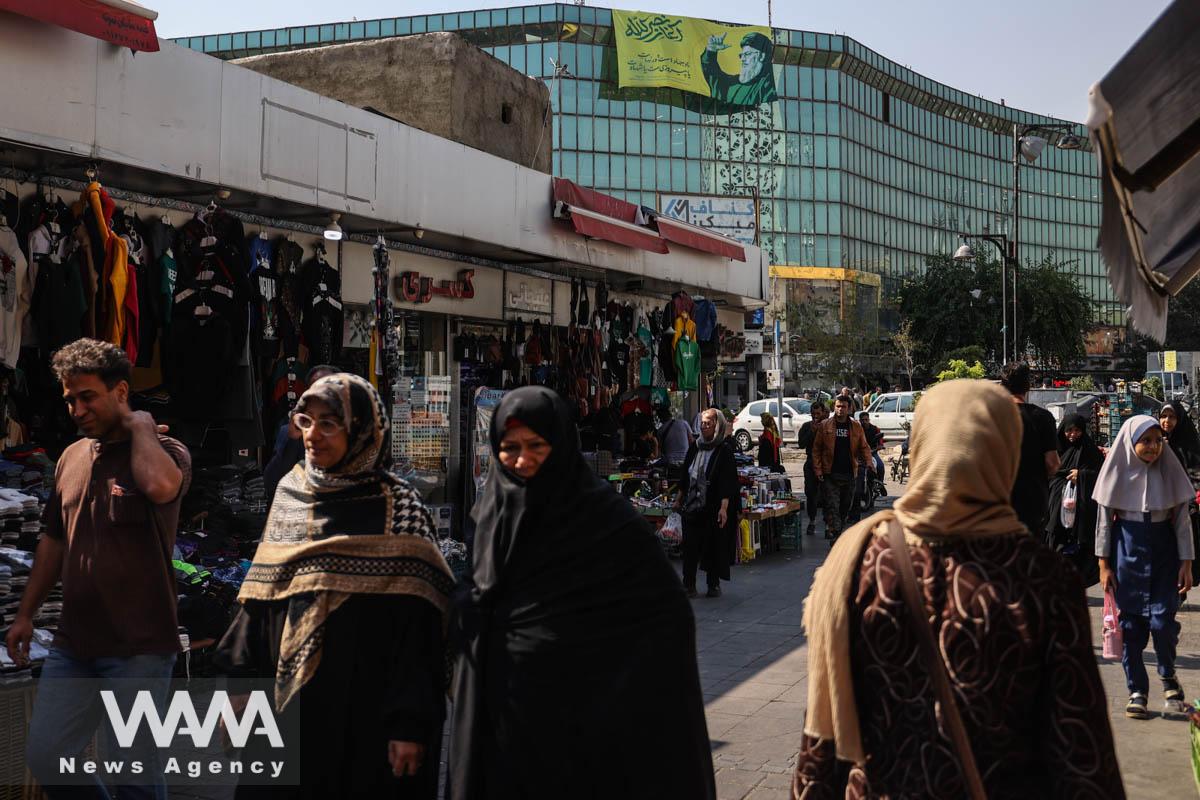 People walk past a billboard with a picture of the late Lebanon's Hezbollah leader Hassan Nasrallah, in a street