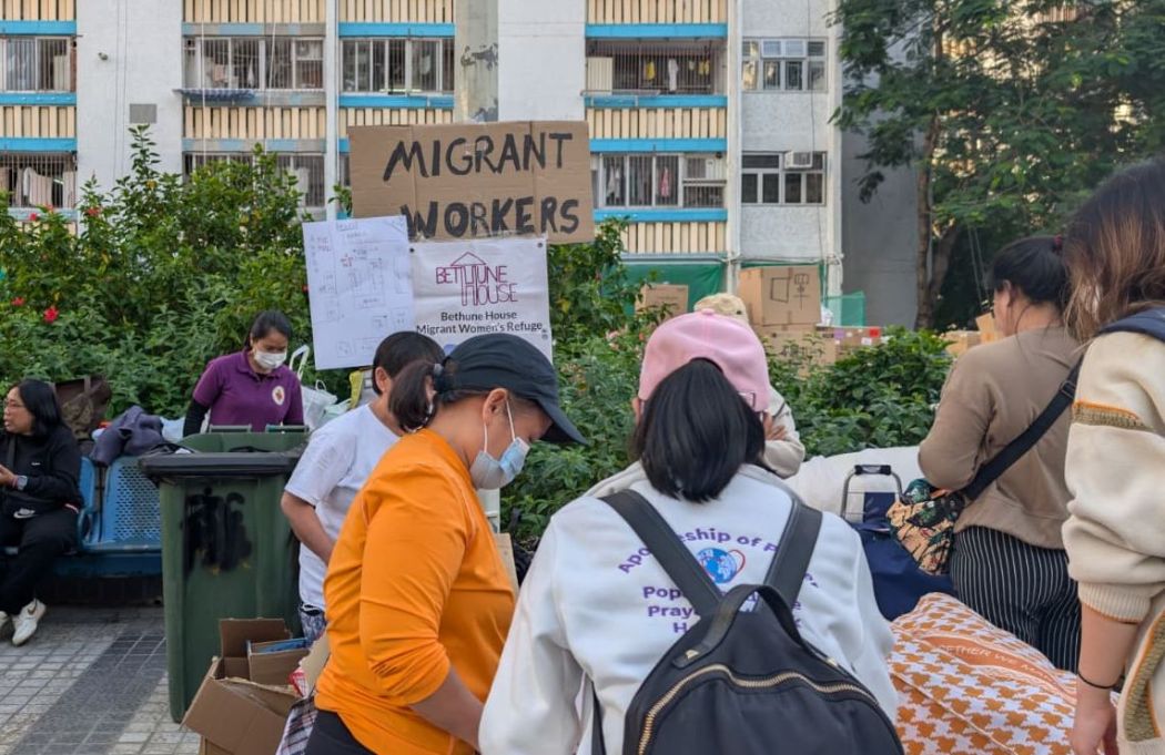 NGOs Mission for Migrant Workers and Bethune House at a podium in Kwong Fuk Estate, next to Wang Fuk Court in Tai Po, on November 28, 2025. Photo: Hillary Leung/HKFP.