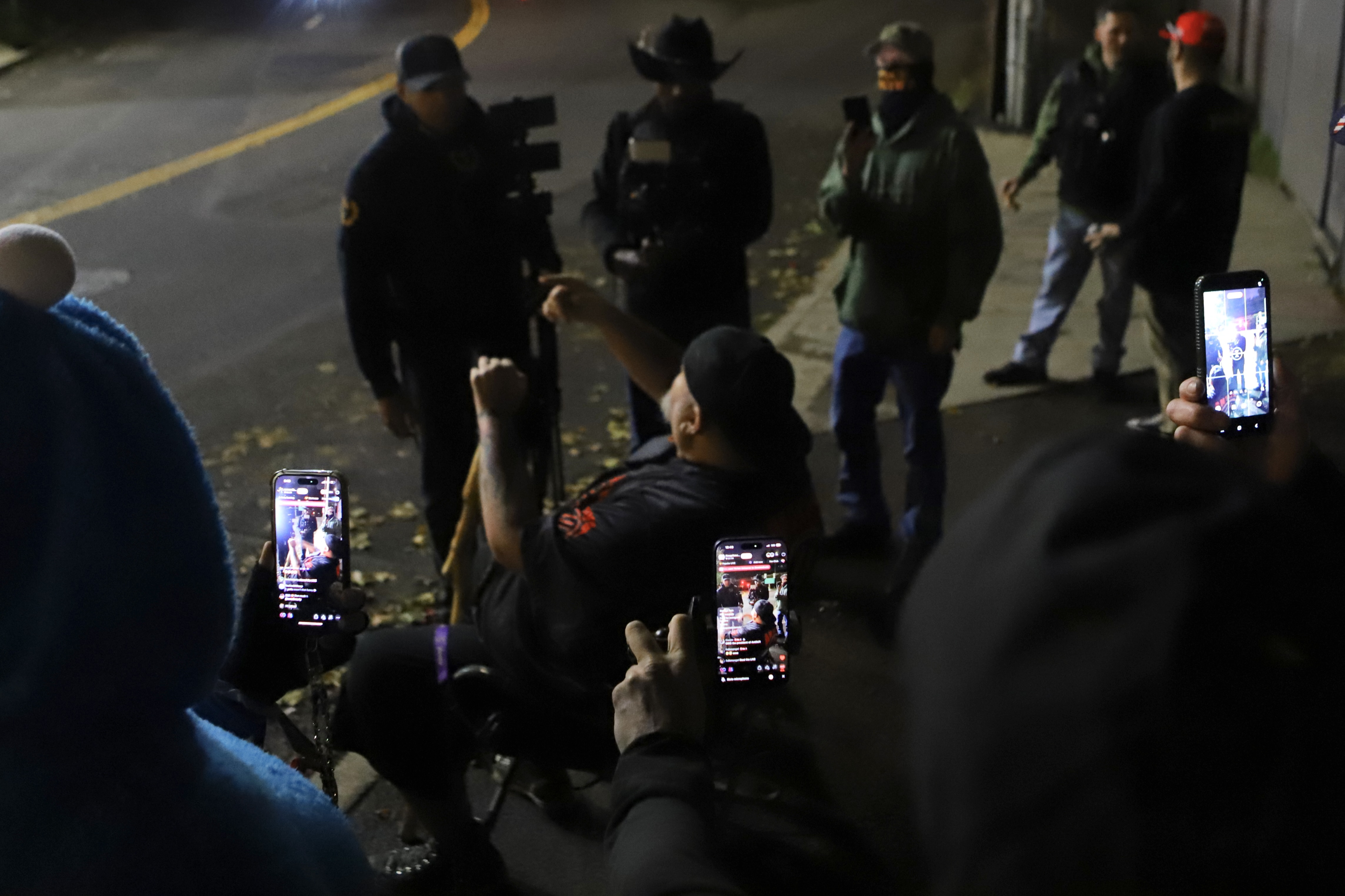 Livestreamers record anti-Trump content creator Michael Duntley, in his "Antifa" jersey, outside the Portland ICE building on Saturday, Nov. 1, 2025.
